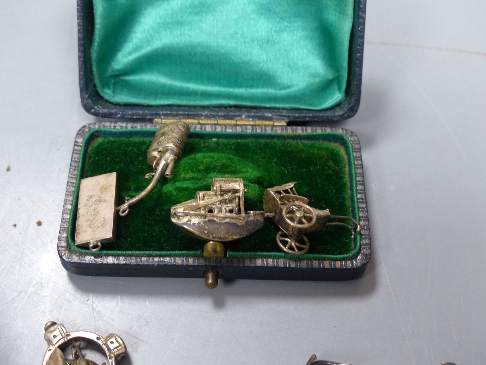 Assorted Chinese white metal items including a menu holder, nail guard, charms, brooches etc.